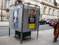 Una persona pasa junto a carteles de los candidatos presidenciales franceses en París.