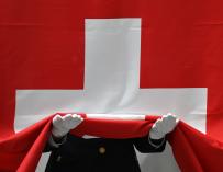 Un soldado recoge la bandera de Suiza.
