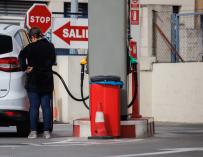 Una mujer reposta carburante en una gasolinera
