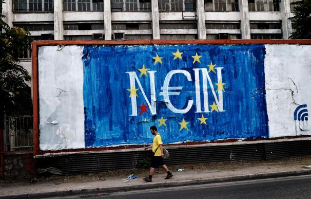 Un hombre pasa delante de un graffitti con la bandera de la UE y un 'no' en alemán (nein)