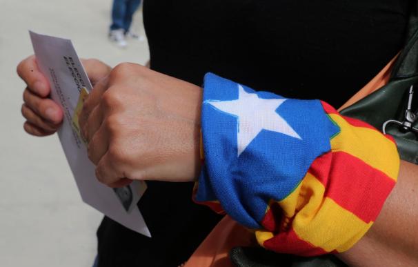 Una mujer acudiendo a votar a las pasadas elecciones del 27S en Cataluña, ataviada con una bandera 'estelada'./AFP