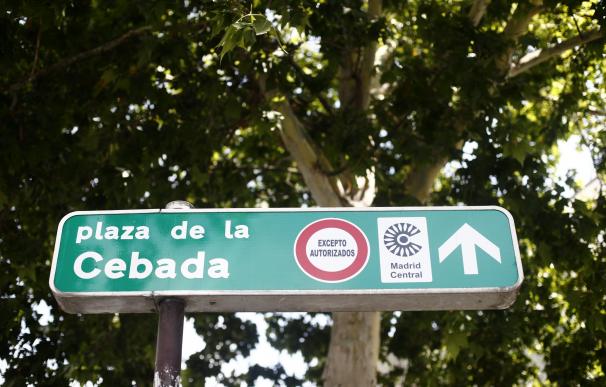 Señal de dirección de la Plaza de la Cebada con símbolo de prohibido aparcar al lado del distintivo de Madrid Central.