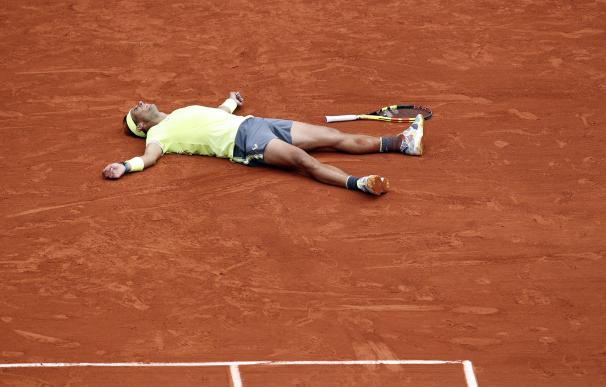 Nadal se deja caer sobre la tierra tras su victoria en la final de Roland Garros. /EFE
