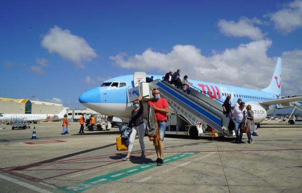 Varios turistas descienden en España de un avión operado por TUI.