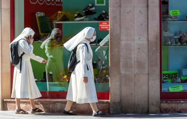 Dos monjas pasan por delante de un comercio en Zaragoza.