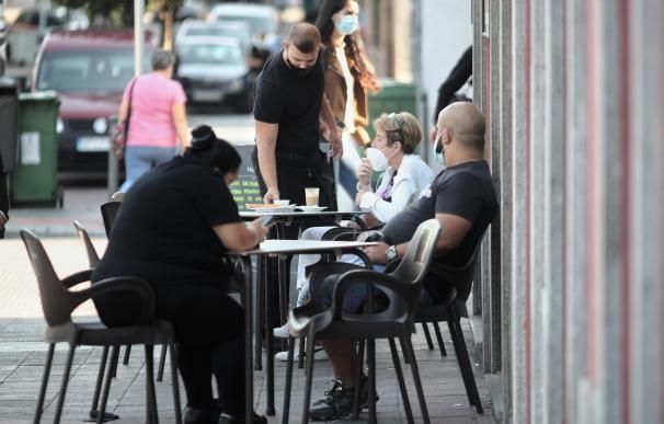 Varias personas sentadas en la terraza de un bar del distrito de Puente de Vallecas, Madrid.