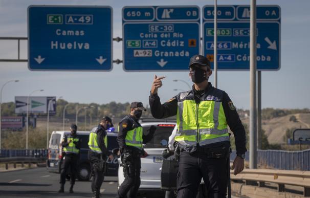 Varios agentes de Policía Nacional realizan un control de movilidad en los alrededores de Sevilla.