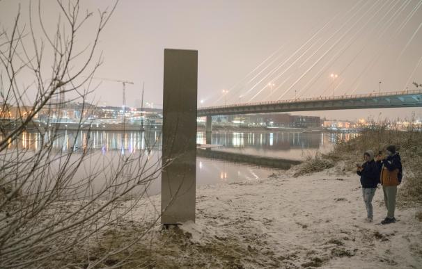 Varias personas observan un misterioso monolito metálico de unos tres metros de altura que fue hallado este jueves a orillas del río Vístula a su paso por Varsovia, sin que