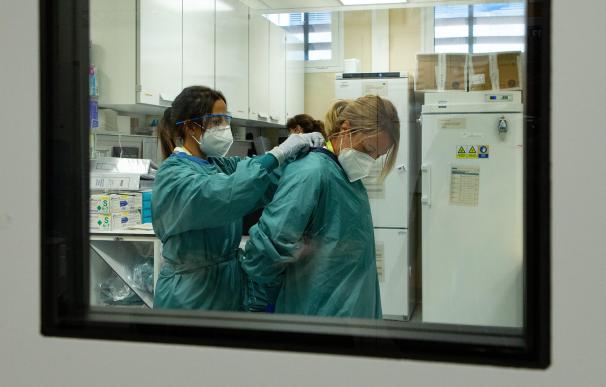 Dos sanitarios se protegen en un centro hospitalario durante la pandemia.