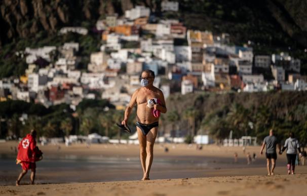 Un turista se pasea por una playa desierta en Canarias durante el mes de diciembre.