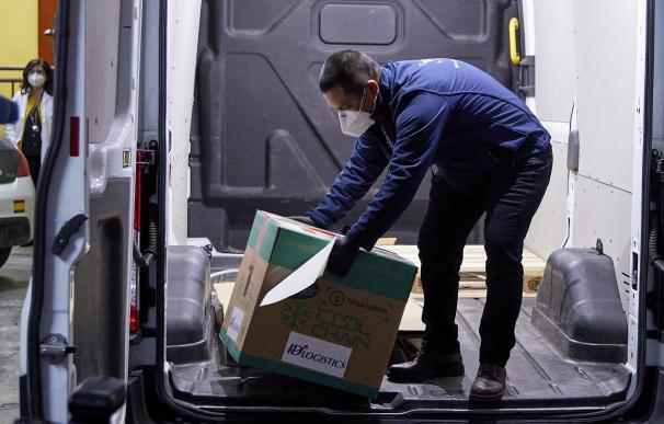 Un operario entrega una caja con dosis de la vacuna de Pfizer y BioNTech en la residencia Los Olmos, el primer día de vacunación contra la Covid-19 en España.