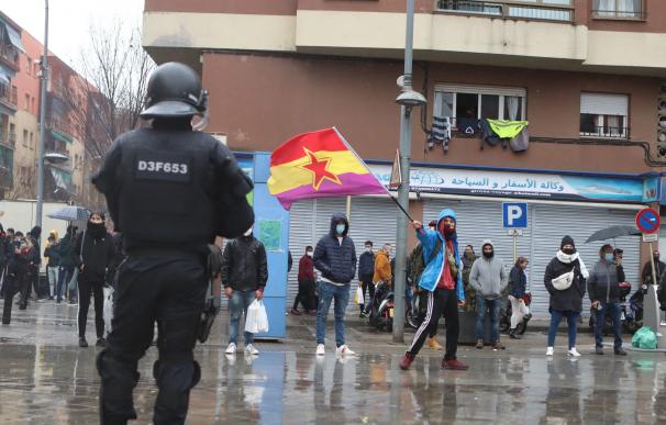 Un agente antidisturbios de los Mossos d'Esquadra frente a los manifestantes que llevan banderas republicanas en Salt, Girona