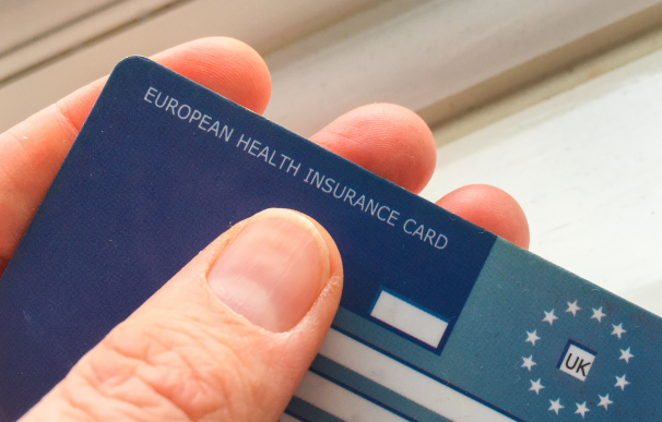 Viajero sosteniendo la tarjeta sanitaria europea.