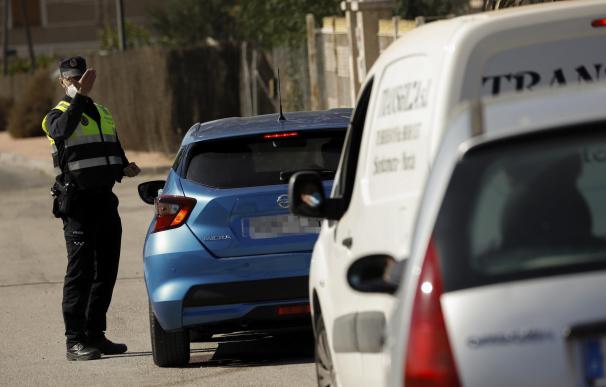 Un policía local ordena detenerse a un coche en un control en el límite entre los municipios de Murcia y Santomera.