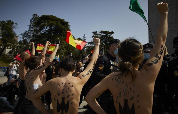 Varias activistas de Femen con águilas franquistas dibujadas en la espalda durante un acto por el Día de la Victoria en el LXXXII Aniversario de la “Liberación de Madrid”, en el Arco de la Victoria, en Madrid.