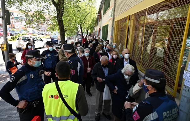 Votantes esperan su turno para ejercer su derecho al voto en el Colegio Pinar del Rey en Madrid