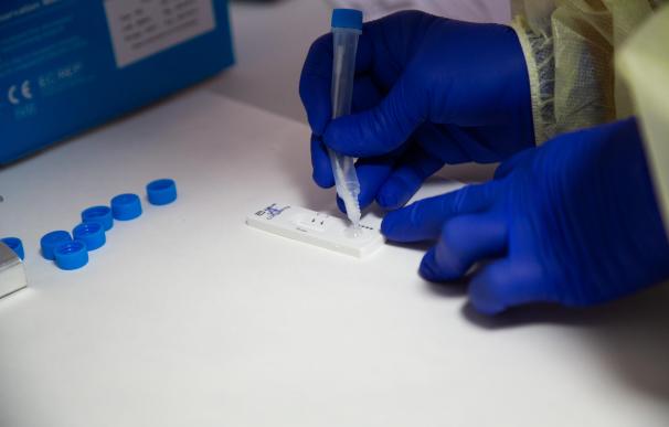 Una sanitaria comprueba el resultado de un test de antígenos, en un dispositivo de cribado masivo.