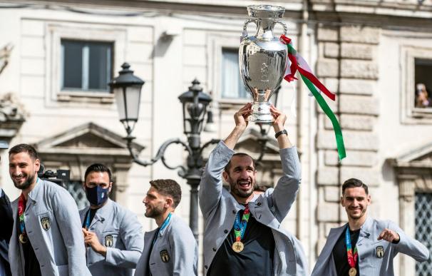 El capitán de la selección italiana de fútbol, Giorgio Chiellini (2d), levanta el trofeo de la Eurocopa a su llegada al Palacio Quirinale, para su encuentro con el presidente italiano, Sergio Mattarella, en Roma.