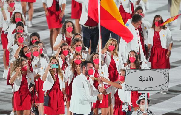 La nadadora Mireia Belmonte y el piragüista Saul Craviotto llevan la bandera española durante la inauguración de los Juegos Olímpicos en Tokio.