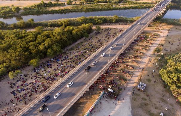 Migrantes esperan ser procesados por los agentes migratorios alrededor y debajo del puente que conecta Del Rio, Texas (EEUU) con Ciudad Ocuna (México).