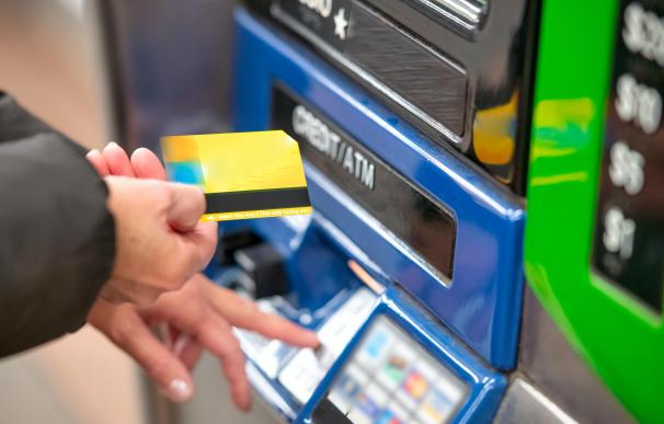 Un usuario utilizando su tarjeta de débito en un cajero automático.