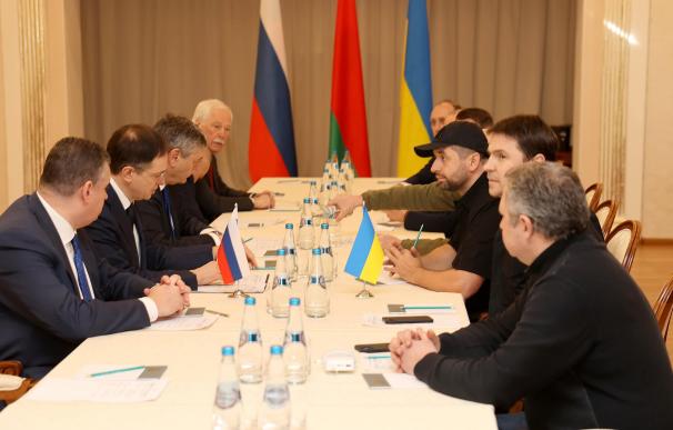 28/02/2022.- Una foto proporcionada por la agencia de noticias BelTA muestra a la delegación rusa (izq.), incluido el asistente presidencial ruso Vladimir Medinsky (2-izq.), y la delegación ucraniana (der.) asistiendo a Rusia -Negociaciones de Ucrania en la región de Gomel en Bielorrusia.