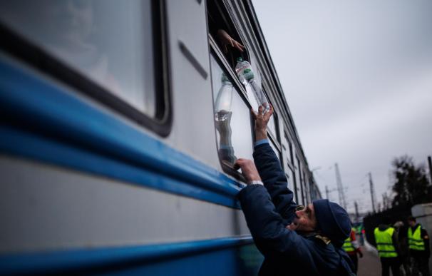 Un hombre entrega una botella de agua a uno de los vagones de la estación de tren de Lviv, a 2 de marzo de 2022, en Leópolis (Ucrania). Esta ciudad se ha convertido en las últimas semanas en el destino elegido por los evacuados de áreas en el este del país. Las autoridades de la ciudad ucraniana de Leópolis han impuesto un toque de queda nocturno, ante la invasión militar de Rusia en Ucrania. Según ha informado la Alcaldía de esta ciudad, se limita la salida y circulación de los ciudadanos entre las 22.00 y las 6.00 horas (hora local). 02 MARZO 2022;ESTACIÓN DE TREN;UCRANIA;LEÓPOLIS;TOQUE DE QUEDA;UCRANIANOS;REFUGIADOS Alejandro Martínez Vélez / Europa Press 02/3/2022