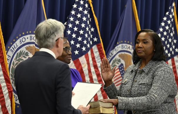 Powell (espaldas) coge juramento a la gobernadora Lisa Cook.