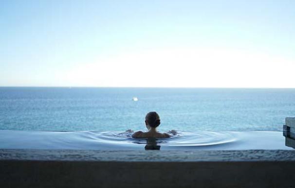 Una joven se baña en una piscina infinita