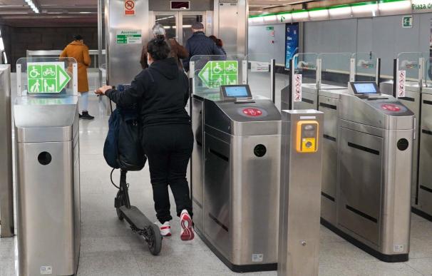 Una usuaria entra con su patinete en el Metro de Sevilla.