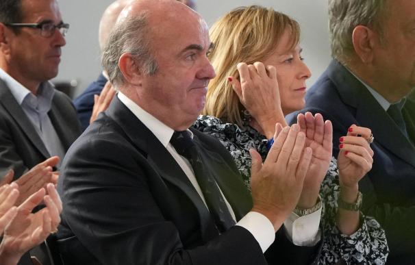 El vicepresidente del BCE, Luis de Guindos, aplaude junto a consejeros del Gobierno vasco en un acto institucional.