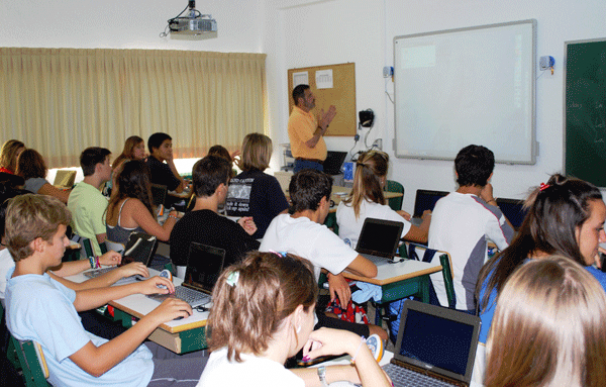 Los alumnos de un aula de 4º de la ESO del Colegio Base equipada con portátiles y pizarra digital.