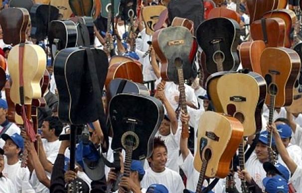 Un grupo de guitarristas alza sus instrumentos en el estadio de Shillong, al noroeste de la India.
