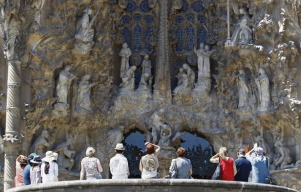 Un grupo de turistas mira la Sagrada Familia de Barcelona el 28 de junio de 2015 (Foto: AFP)