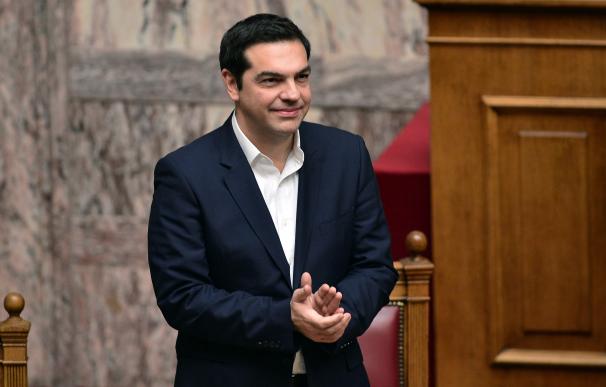 Greek Prime Minister Alexis Tsipras applauds the p