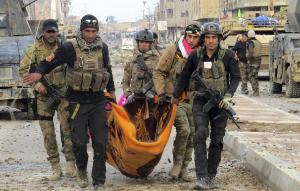 Soldados y miembros de la élite antiterrorista iraquí llevan a un compañero herido en los combates en Ramadi (AFP)