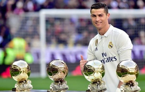 Cristiano Ronaldo posa con sus cuatro Balones de Oro en el Bernabéu.