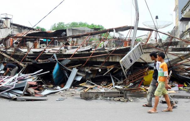Dos niños pasan junto a una casa reducida a escombros tras el potente terremoto que sacudió el miércoles el oeste de la isla de Sumatra. | EFE