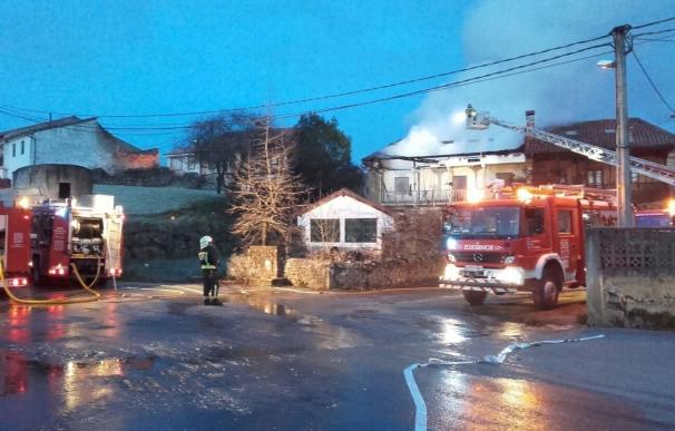 Bomberos trabajan en la extinción de un incendio en una vivienda de Udías que ha quedado inhabitable