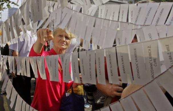 Una mujer lee los nombres de desaparecidos en la guerra colocados frente a la embajada de Croacia en Belgrado en 2005 | Reuters