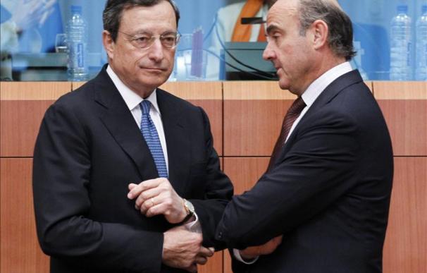 El presidente del Banco Central Europeo (BCE), Mario Draghi (i), y el ministro español de Economía y Competitividad, Luis de Guindos, conversan durante una reunión de ministros de Finanzas de la UE en Bruselas.
