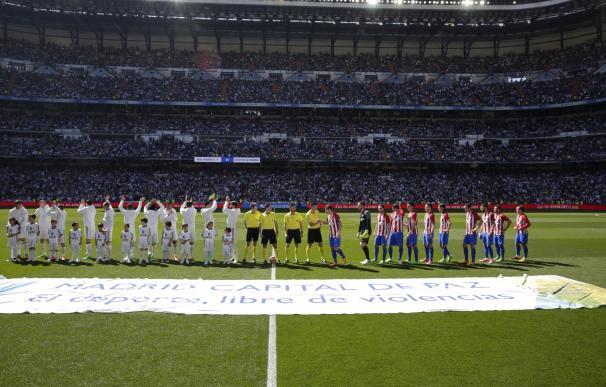 El césped del Bernabéu luce una lona en la que se lee 'Madrid, capital de paz' antes del derbi Real Madrid-Atlético