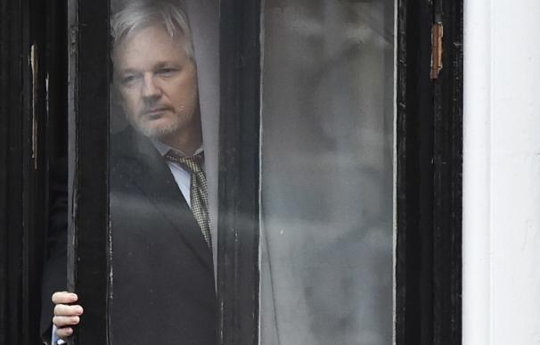 En esta imagen del 5 de febrero de 2016 Julian Assange se asoma al balcón de la embajada de Ecuador en Londres