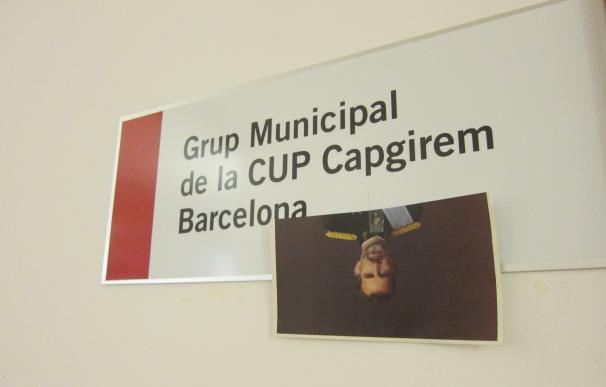 Dos ediles de la CUP en Barcelona guillotinan una foto del Rey