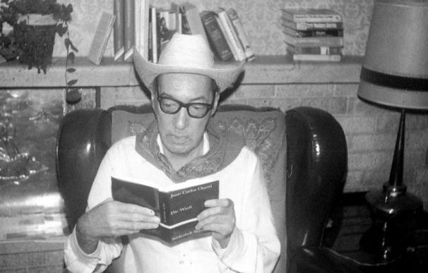 Onetti, disfrazado de vaquero, finge leer una traducción de El astillero