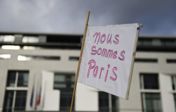 A sign reading "nous sommes Paris" is pictured out