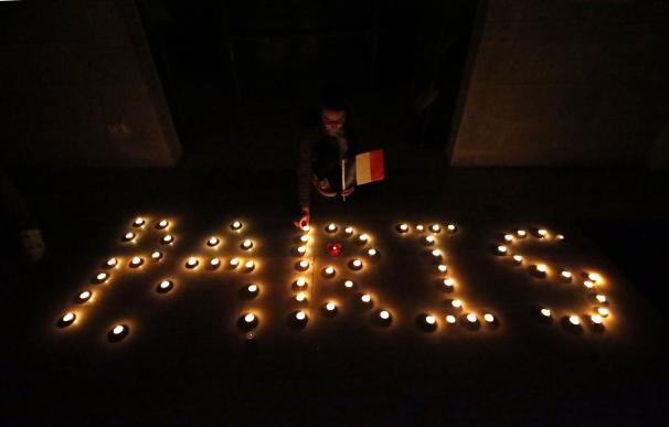 Palestinians arrange candles to spell, Paris, duri