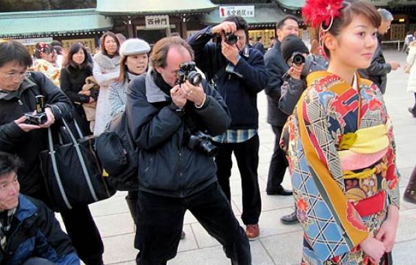Una joven en su puesta de largo en Meiji Jingu (Tokio) rodeada de fotógrafos