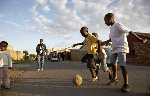 Unos niños practican fútbol en las calles del barrio de Soweto (Sudáfrica), donde arrancará en junio el Mundial 2010.