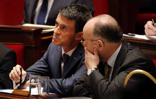 French Prime Minister Manuel Valls (L) listens to